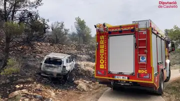 Un equipo de bomberos junto al vehículo que ha provocado el incendio en Castellón
