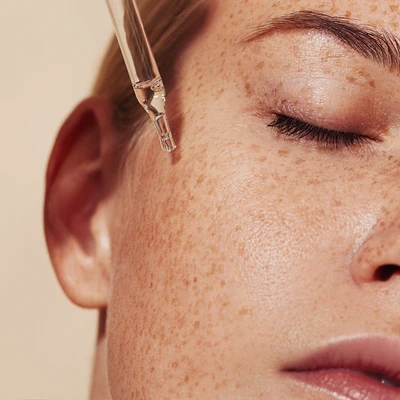 Mujer bronceada aplicándose retinol